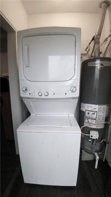 clothes washing area with laundry area, gas water heater, and stacked washer / drying machine