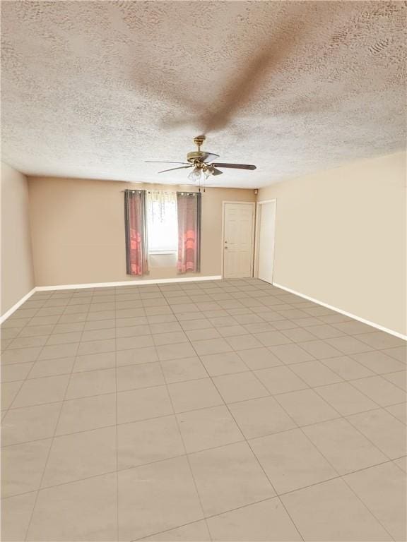 empty room with a textured ceiling, baseboards, and ceiling fan