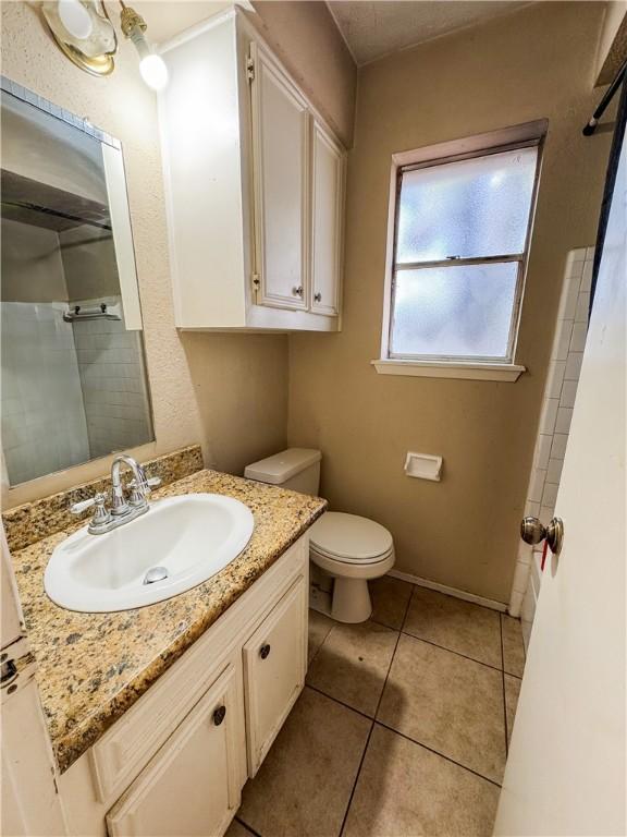 full bathroom featuring vanity, a shower with curtain, toilet, and tile patterned flooring