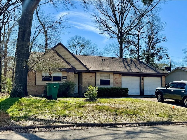 view of front of home with brick siding, an attached garage, and driveway