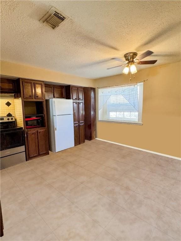 kitchen featuring a ceiling fan, baseboards, visible vents, electric range, and freestanding refrigerator