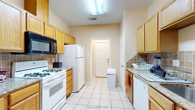 609 Townplace Dr, College Station, TX 77840 - kitchen featuring white appliances, light brown cabinetry, light tile patterned floors, and decorative backsplash