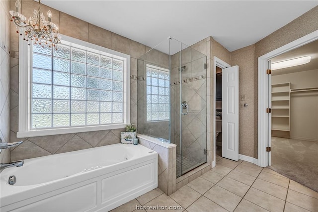 bathroom featuring tile patterned floors, plenty of natural light, independent shower and bath, and a notable chandelier