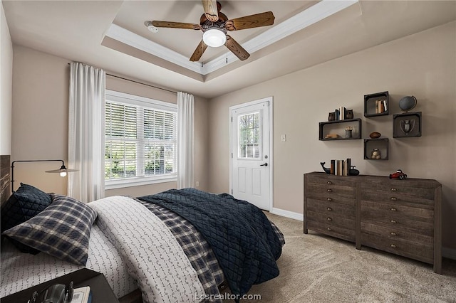 carpeted bedroom featuring a raised ceiling, ceiling fan, and ornamental molding