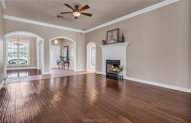 unfurnished living room featuring hardwood / wood-style floors, ceiling fan with notable chandelier, and ornamental molding