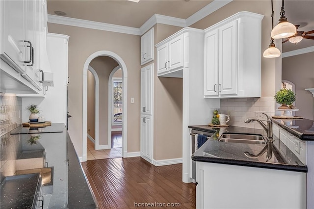 kitchen with dark hardwood / wood-style flooring, sink, decorative light fixtures, dark stone countertops, and white cabinetry