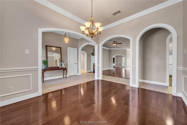 unfurnished dining area featuring crown molding, light hardwood / wood-style flooring, and ceiling fan with notable chandelier