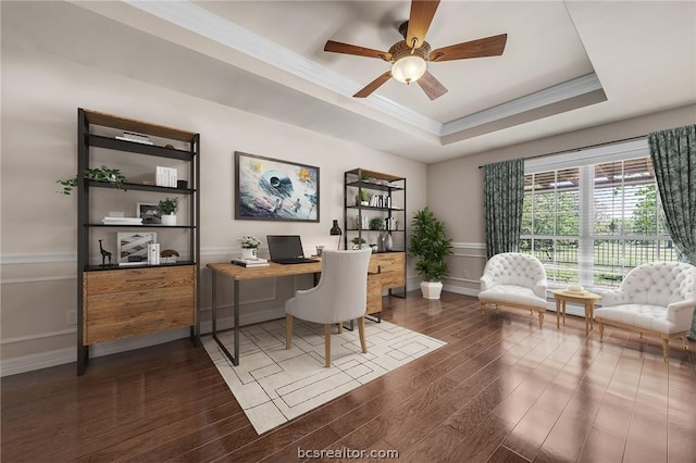 office with ornamental molding, a tray ceiling, ceiling fan, and dark wood-type flooring