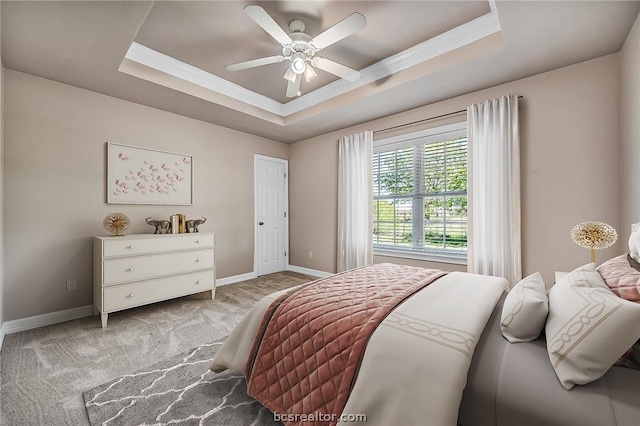 carpeted bedroom featuring a tray ceiling, ceiling fan, and ornamental molding