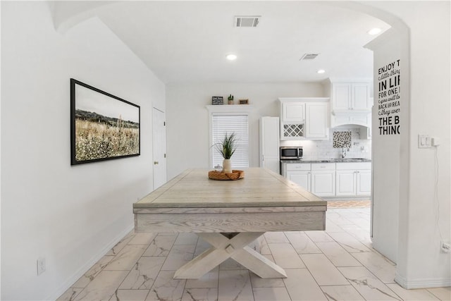 kitchen with white cabinetry, sink, decorative backsplash, and white fridge