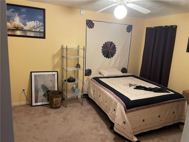 bedroom with a textured ceiling, carpet floors, and ceiling fan