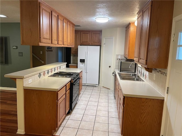 kitchen with tasteful backsplash, a breakfast bar, a textured ceiling, stainless steel appliances, and light tile patterned floors