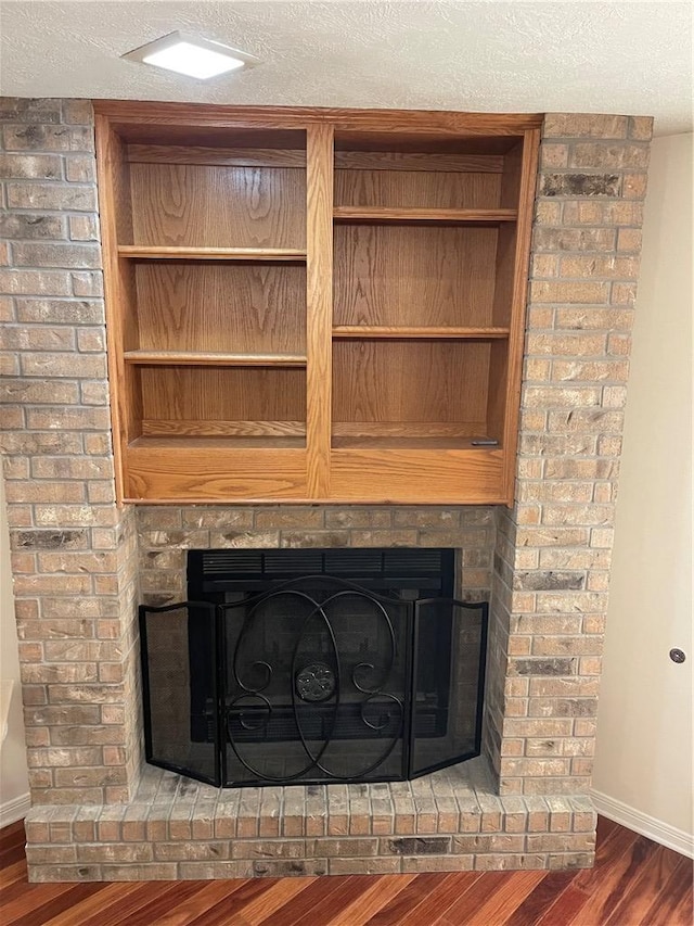 details with hardwood / wood-style floors, a fireplace, and a textured ceiling