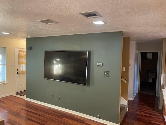 interior space with a textured ceiling and dark wood-type flooring