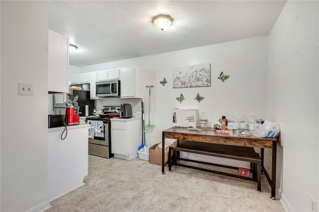 kitchen featuring white cabinets, appliances with stainless steel finishes, a textured ceiling, and light countertops