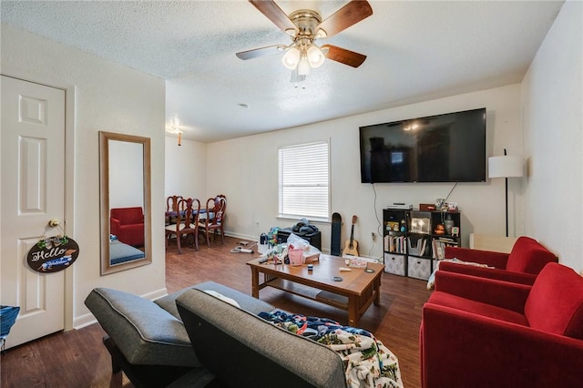 living room featuring baseboards, a textured ceiling, ceiling fan, and wood finished floors