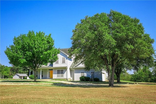 view of property hidden behind natural elements featuring a front lawn