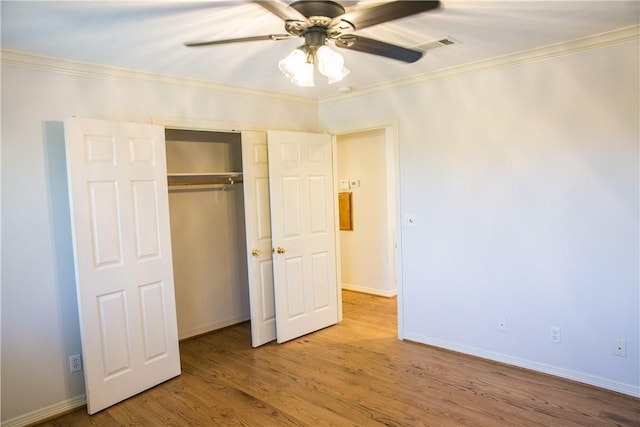 unfurnished bedroom featuring ceiling fan, ornamental molding, light hardwood / wood-style floors, and a closet