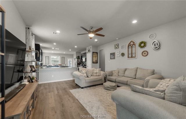 living room with ceiling fan and hardwood / wood-style floors