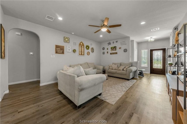 living room with dark hardwood / wood-style floors and ceiling fan