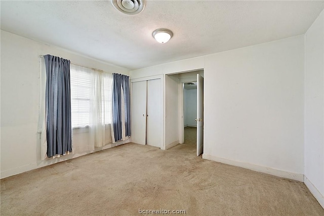 carpeted spare room featuring a textured ceiling