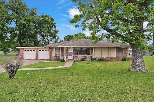 ranch-style house featuring covered porch, a garage, and a front lawn