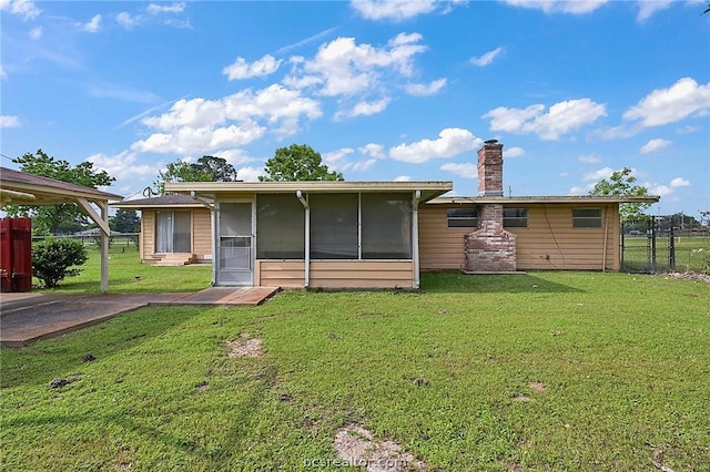 back of house featuring a yard and a sunroom