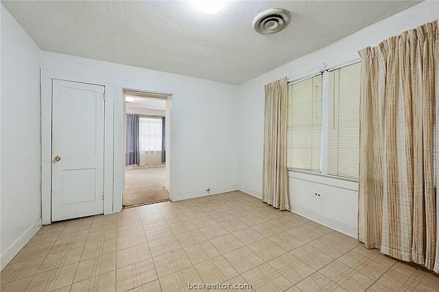 spare room featuring a textured ceiling