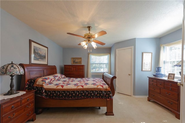 carpeted bedroom with a textured ceiling and ceiling fan