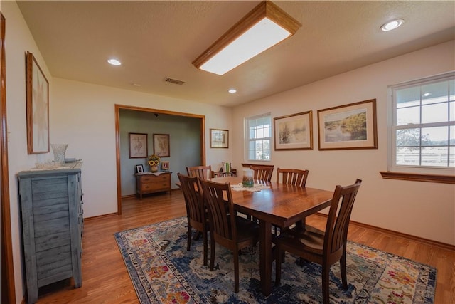 dining area featuring plenty of natural light, hardwood / wood-style floors, and a textured ceiling