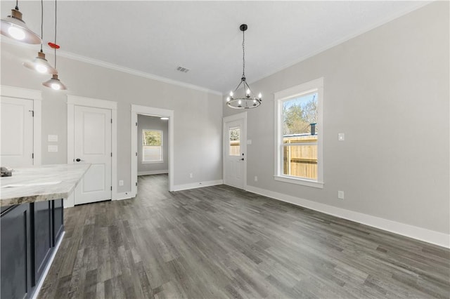 unfurnished dining area with plenty of natural light, dark hardwood / wood-style floors, crown molding, and a chandelier