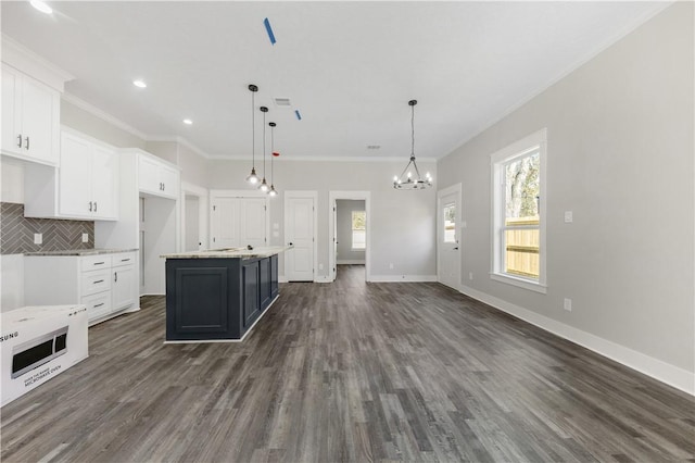 kitchen with white cabinets, dark wood-type flooring, a kitchen island, and pendant lighting