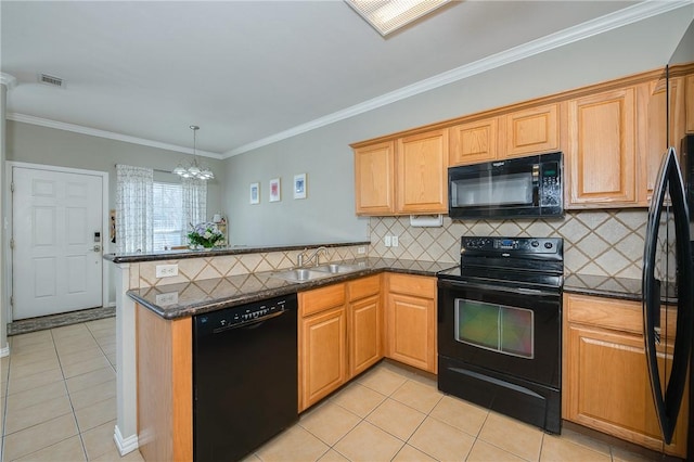 kitchen featuring a peninsula, black appliances, visible vents, and a sink