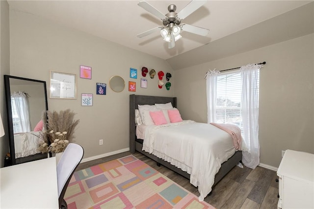 bedroom with lofted ceiling, dark wood finished floors, baseboards, and ceiling fan