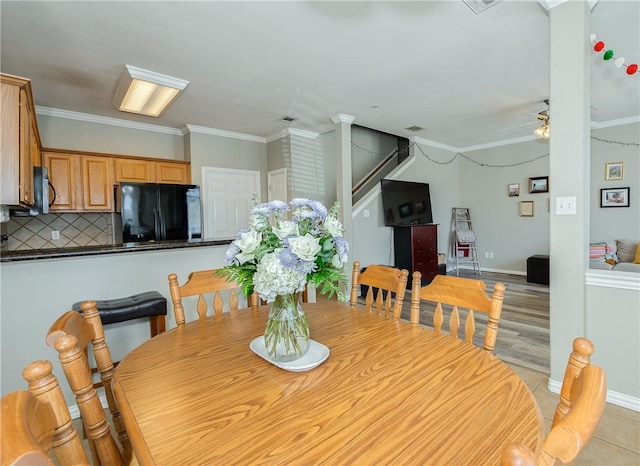 dining area featuring ornamental molding, stairway, a ceiling fan, and baseboards