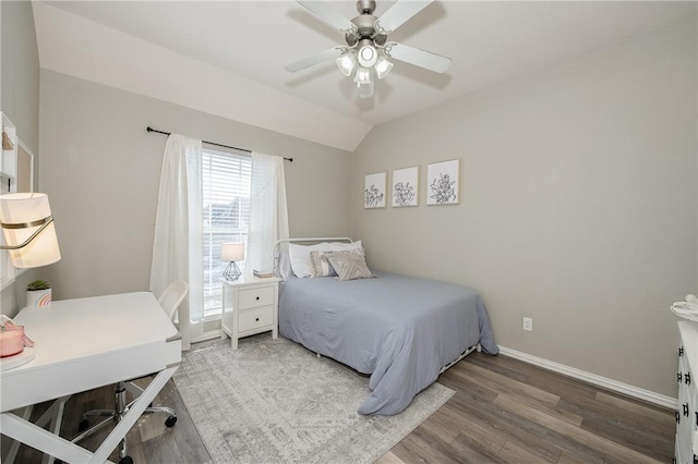 bedroom with a ceiling fan, vaulted ceiling, baseboards, and wood finished floors