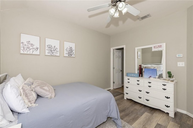 bedroom with a ceiling fan, dark wood-style flooring, visible vents, and baseboards