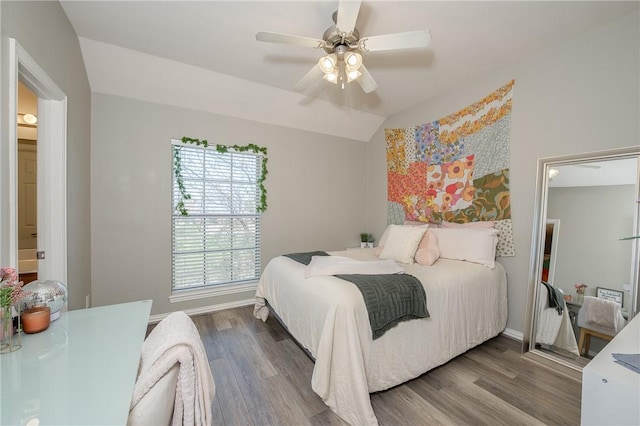 bedroom featuring ceiling fan, baseboards, vaulted ceiling, and wood finished floors