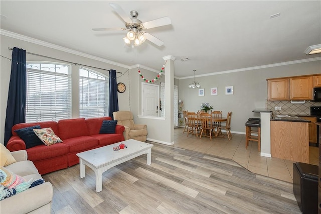 living area featuring light wood-type flooring, baseboards, ornamental molding, and ceiling fan with notable chandelier