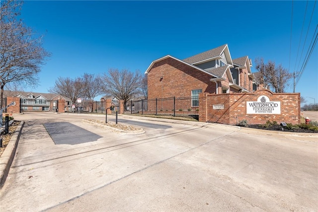 view of road featuring a residential view, a gate, and curbs