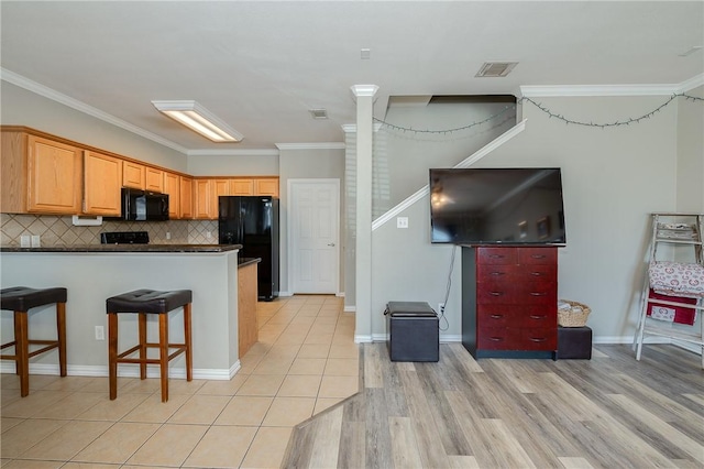 kitchen with tasteful backsplash, visible vents, dark countertops, ornamental molding, and black appliances