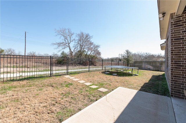 view of yard featuring a trampoline and a fenced backyard