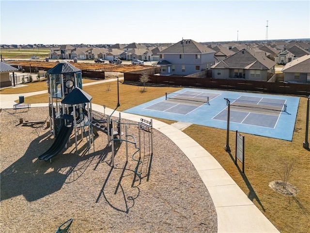 view of community with a tennis court, a residential view, fence, and playground community