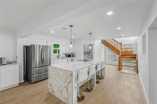 2430 E Briargate Dr, Bryan, TX 77802 - kitchen with freestanding refrigerator, a sink, white cabinetry, light wood-type flooring, and recessed lighting