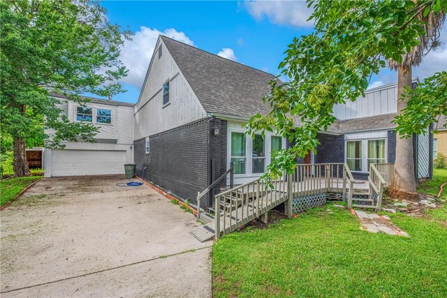 2430 E Briargate Dr, Bryan, TX 77802 - view of front of property with brick siding, a shingled roof, a front lawn, a wooden deck, and a garage