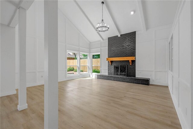 2430 E Briargate Dr, Bryan, TX 77802 - unfurnished living room featuring a decorative wall, high vaulted ceiling, a chandelier, beamed ceiling, and light wood-type flooring