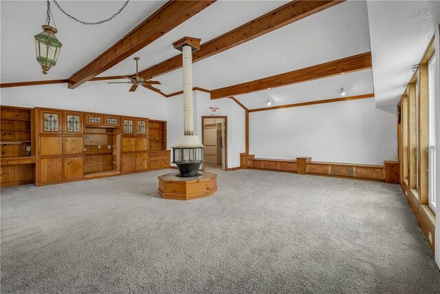 2430 E Briargate Dr, Bryan, TX 77802 - unfurnished living room with a wood stove, beamed ceiling, carpet floors, a ceiling fan, and high vaulted ceiling