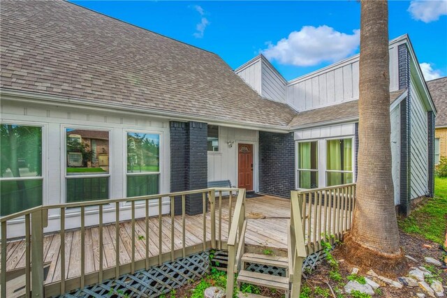 2430 E Briargate Dr, Bryan, TX 77802 - property entrance featuring a shingled roof, a wooden deck, and brick siding