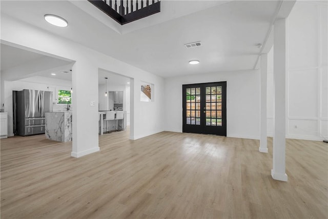2430 E Briargate Dr, Bryan, TX 77802 - entryway with light wood-type flooring, french doors, and baseboards