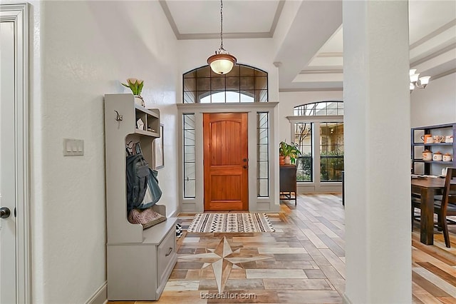 entrance foyer with light hardwood / wood-style flooring, ornamental molding, and a notable chandelier